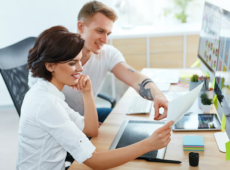 Zwei Webdesigner besprechen einen Entwurf am Arbeitsplatz