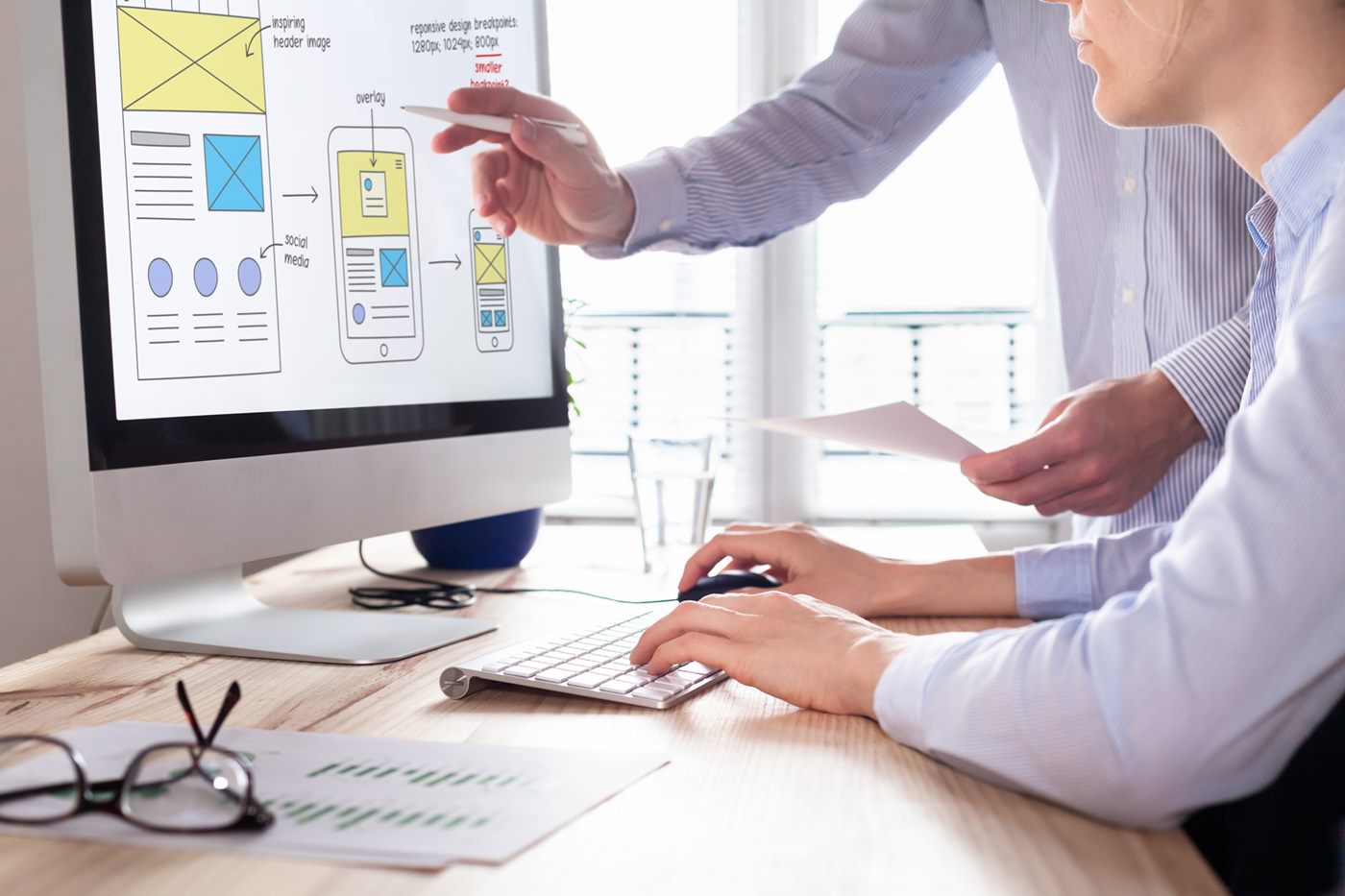 Webdesigner erklären am Bildschirm ein responsives Layout
